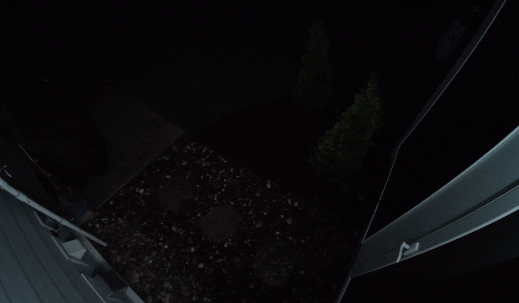 A man in a blue hoodie trying to open a backdoor and then running away after Arlo Pro 6 camera light shines on him