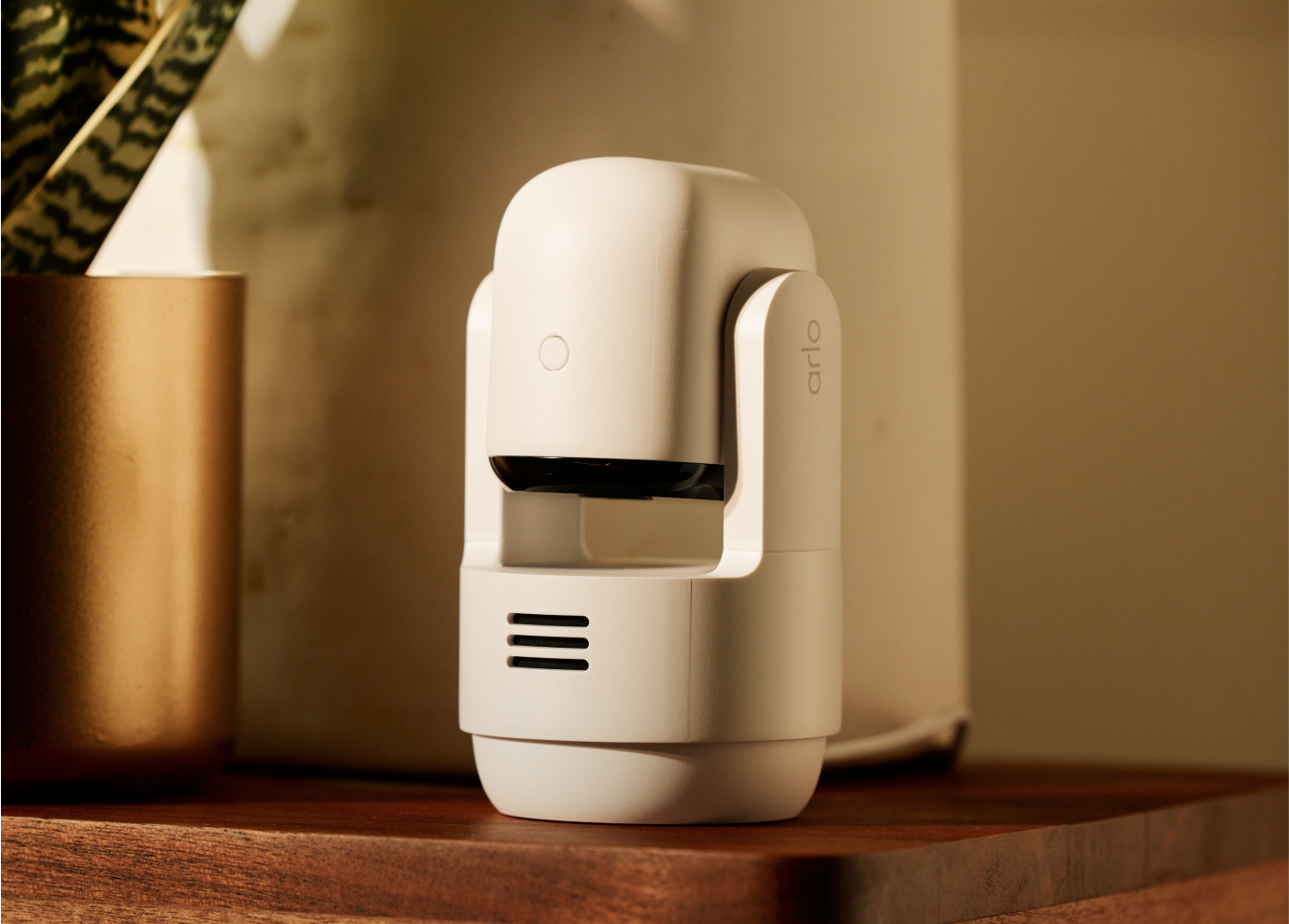 Arlo Essential Pan Tilt Indoor camera on top of a wooden tablet