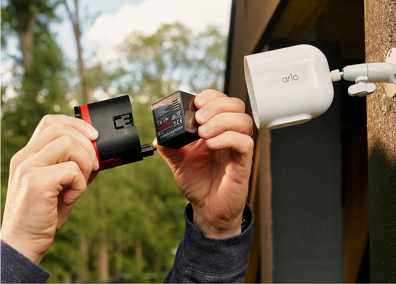 A person replacing the swappable battery from the Arlo Ultra 3rd Gen camera