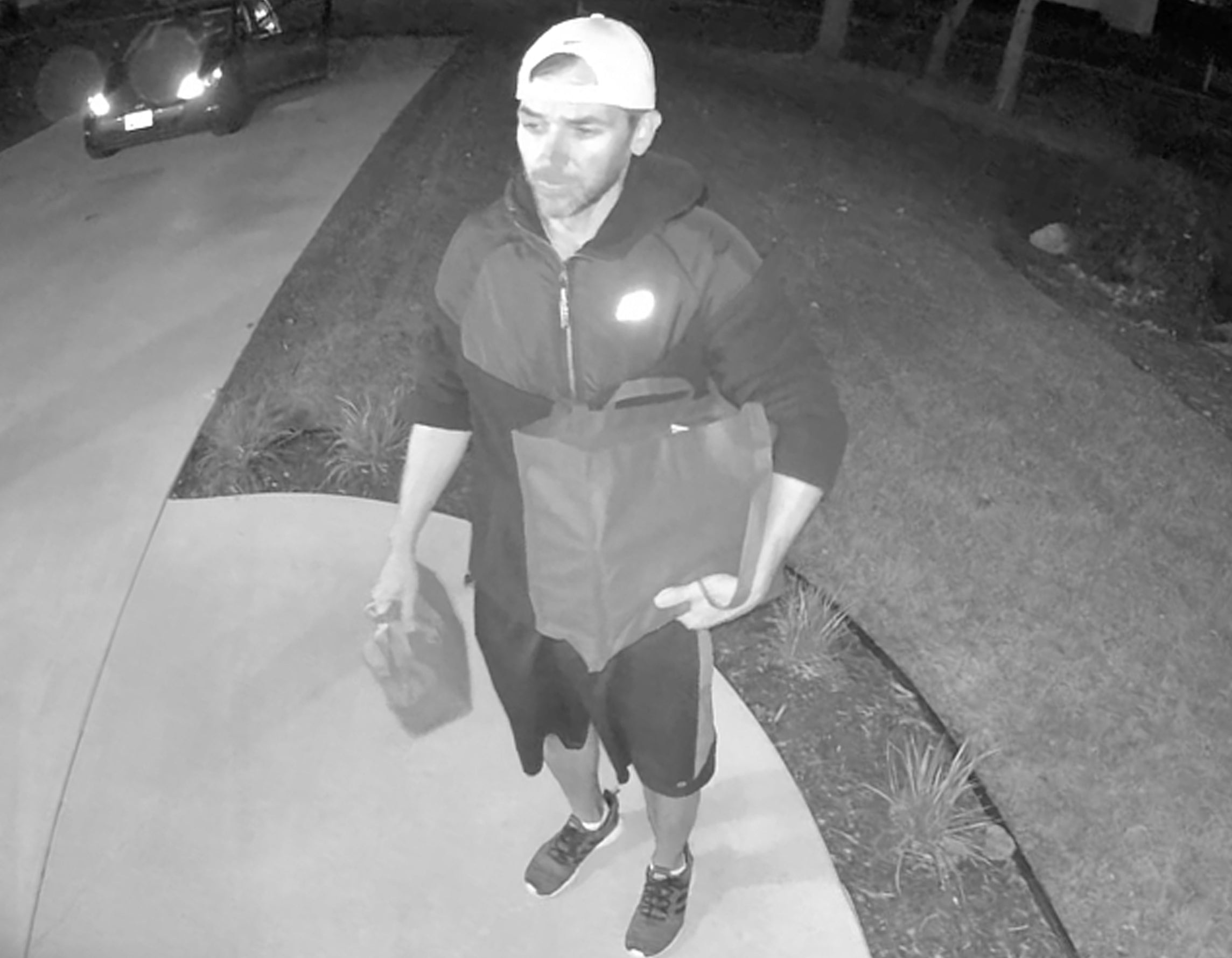 A man delivering food at the front door at night