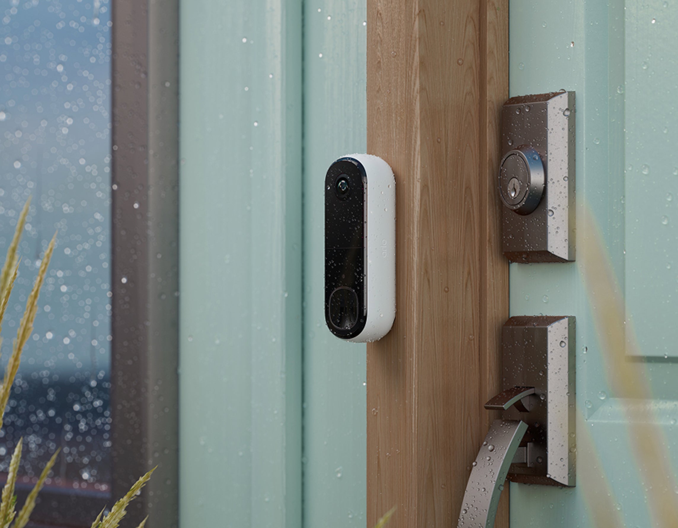 Arlo Video Doorbell mounted on the side of a front door in the rain