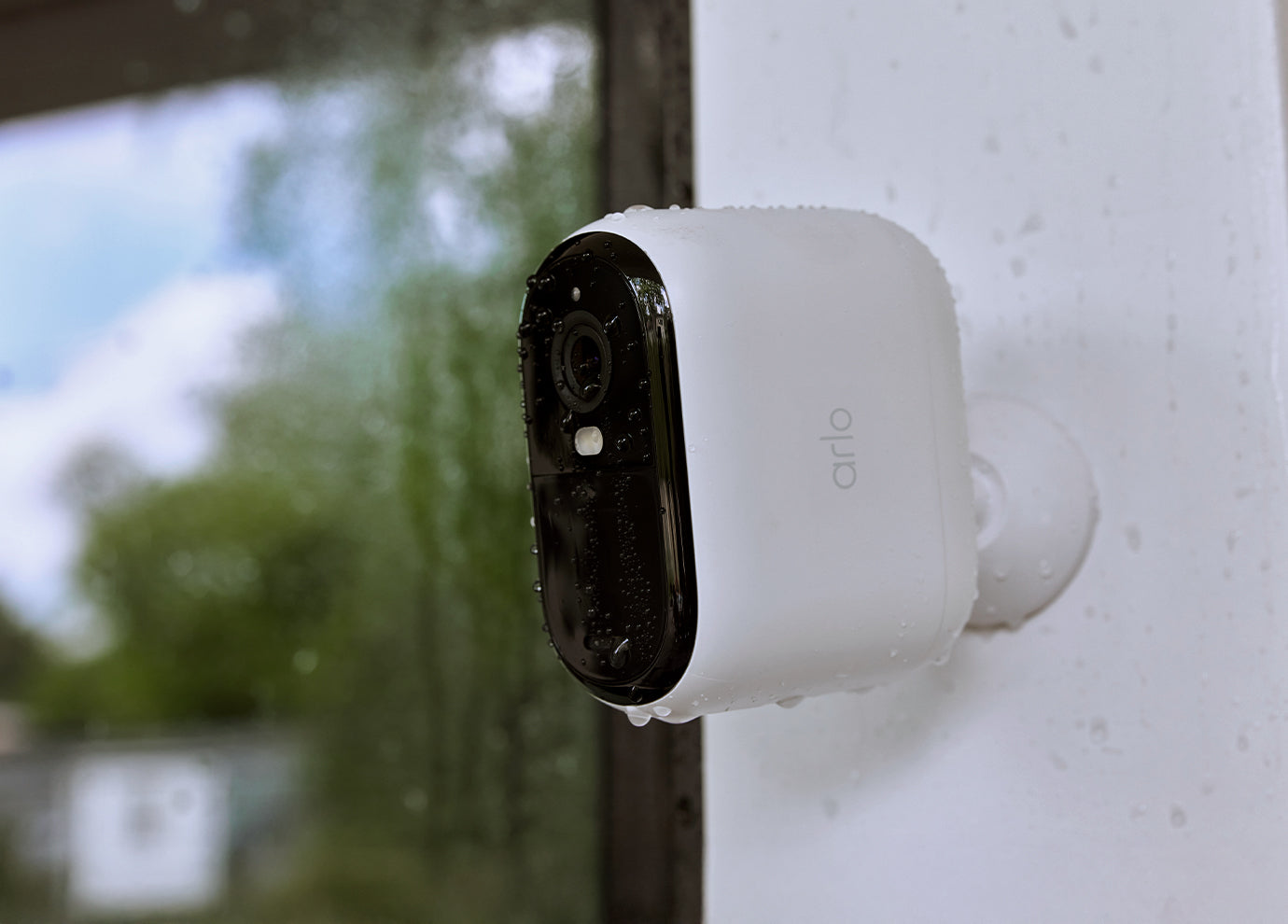 Arlo Essential 3rd Gen XL camera mounted on a side of a house in the rain