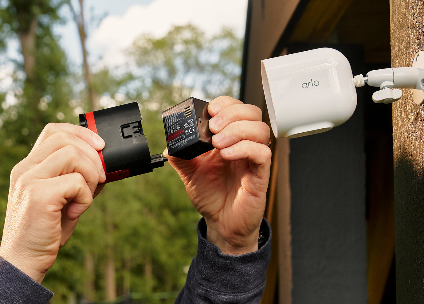 A hand taking out a rechargeable battery from the Arlo Pro 6 camera