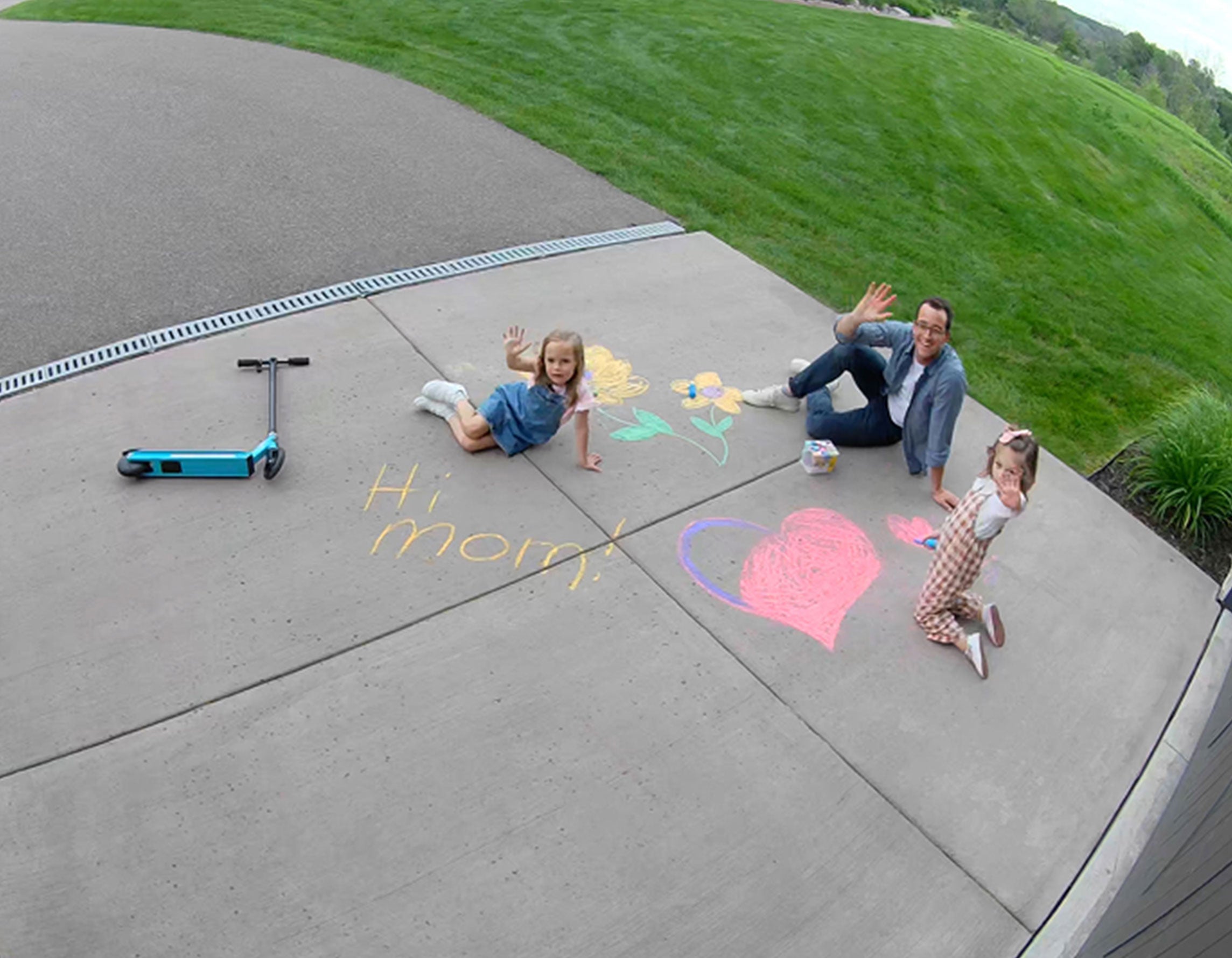 A family waving outside in front of their garage