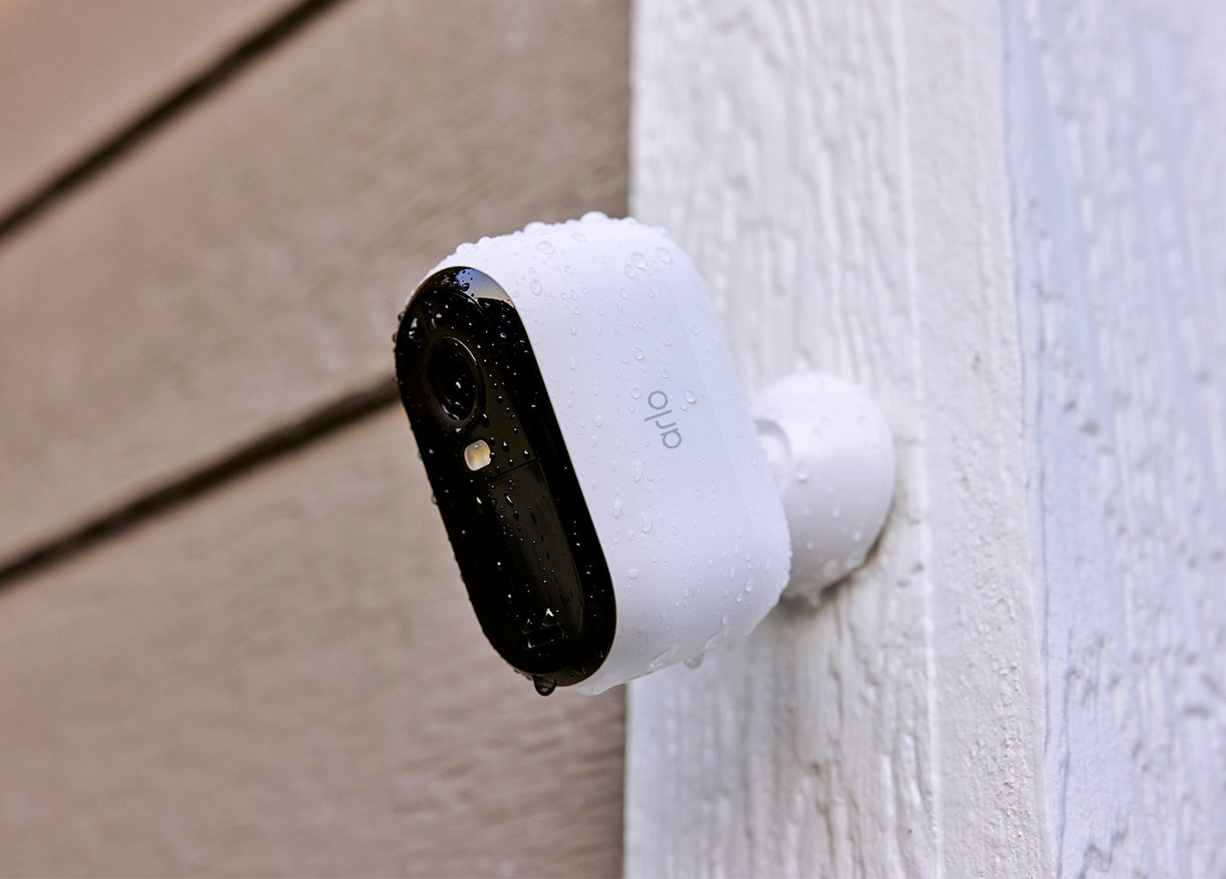 Arlo Essential 3rd Gen camera mounted on the side of a house in the rain