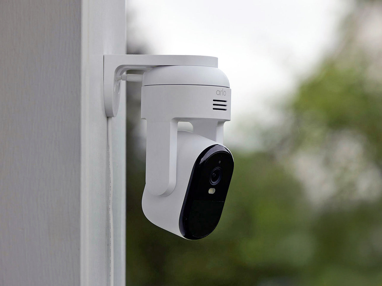 Arlo Essential Pan Tilt camera mounted on side of a house