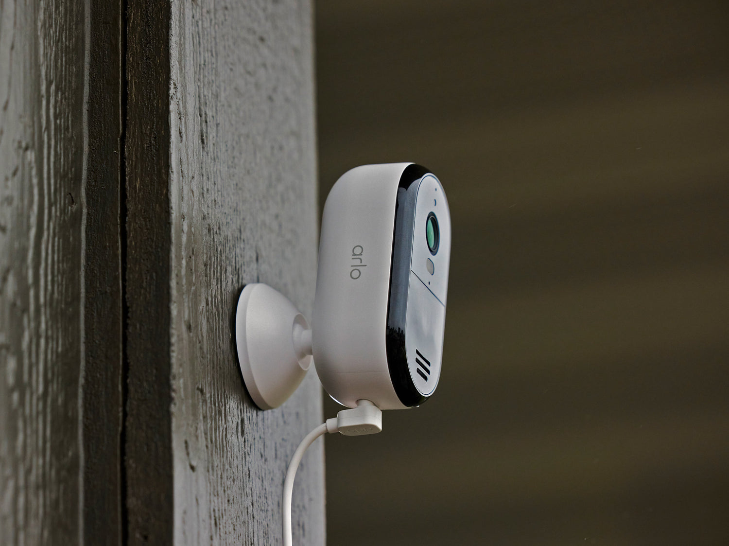 Arlo Essential Plug-in camera mounted on wood