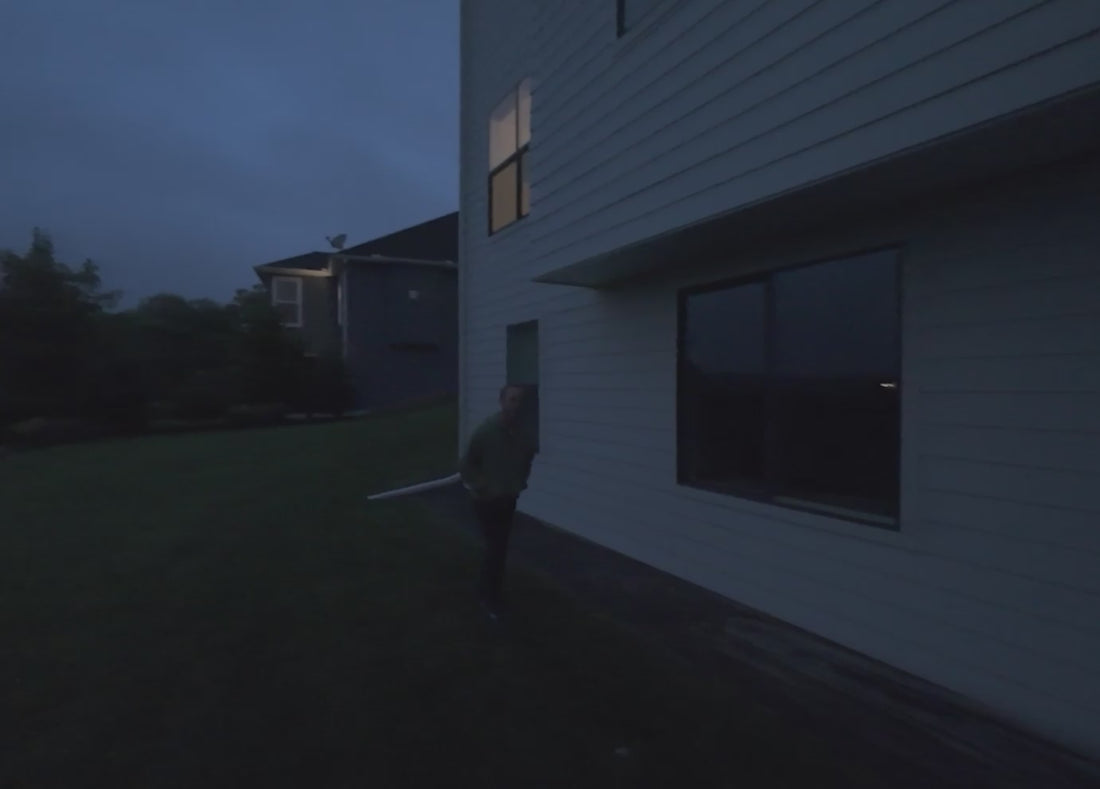 A man trying to open a sliding door and then a light shines on him and the man runs away animation