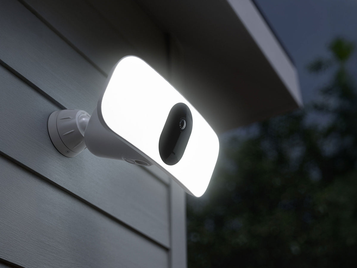 Arlo Wireless Floodlight in white illuminated at night