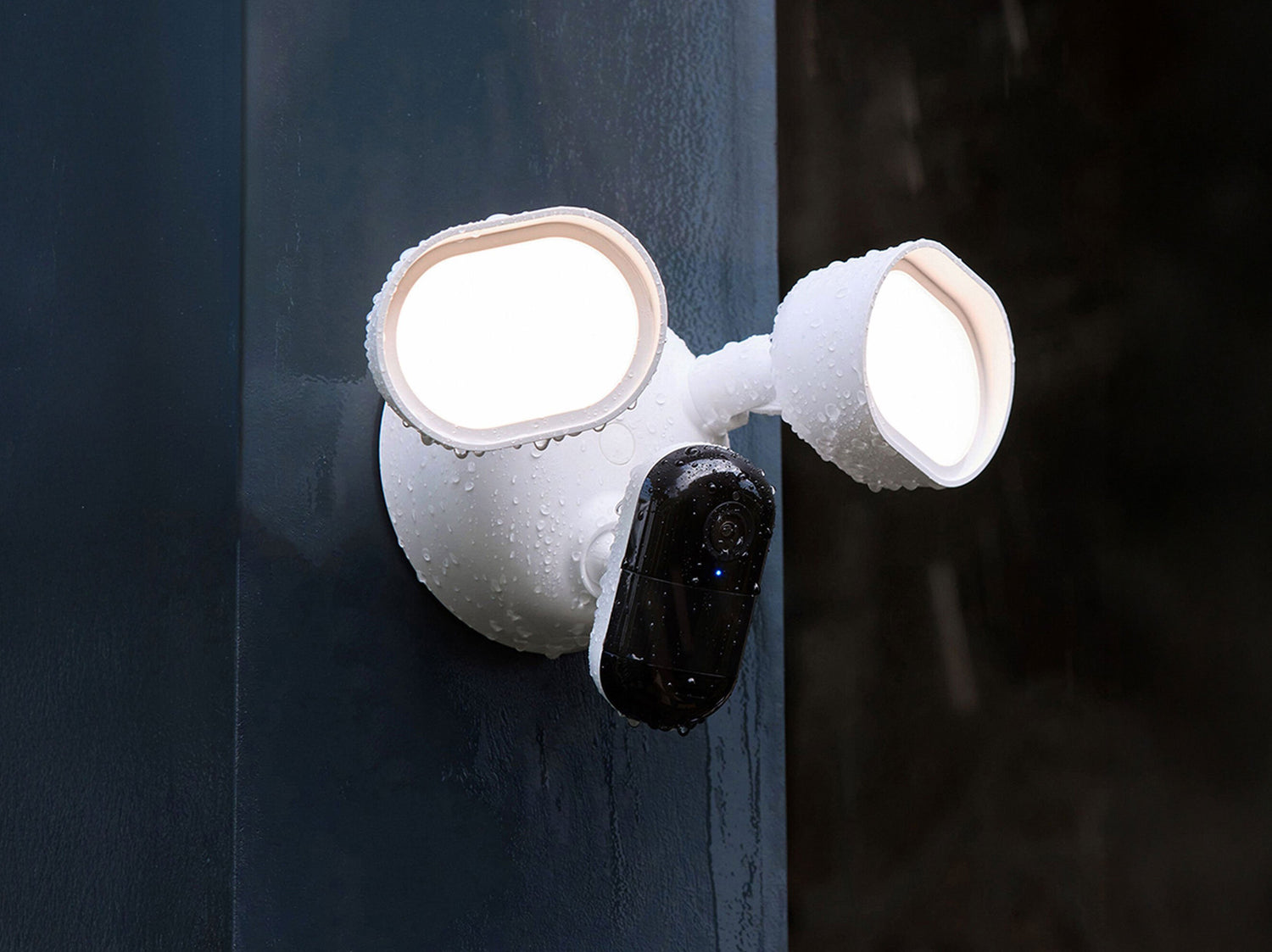 Arlo Wired Floodlight at night with lights on in the rain