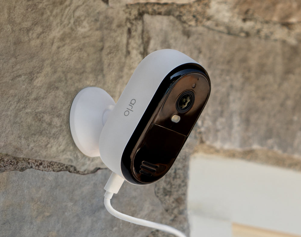 Arlo Essential Plug-in camera mounted on stone
